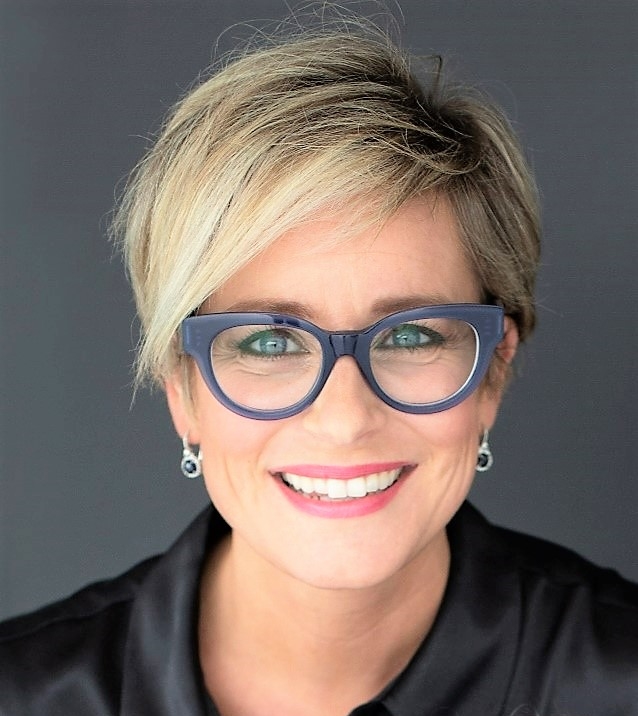 A woman with blonde hair and wearing glasses